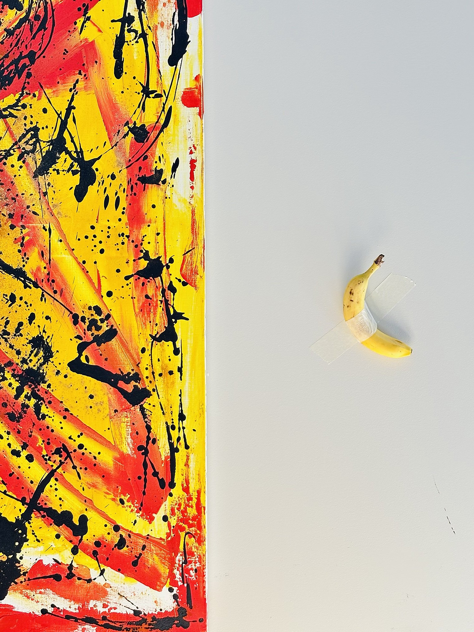 Toile rouge et jaune, et une banane scotchée au mur