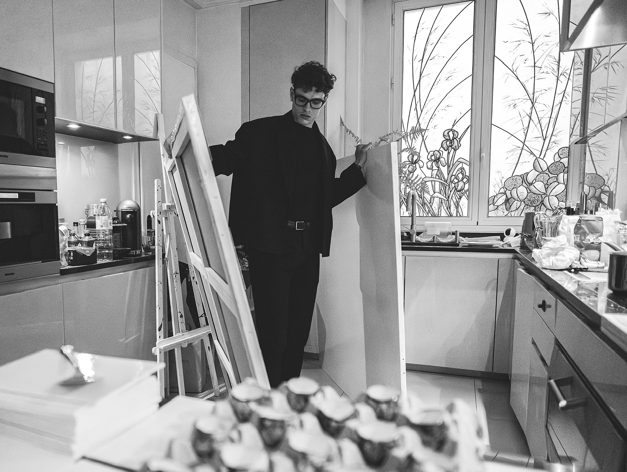 Romain Meignan dans sa cuisine, entouré de toiles